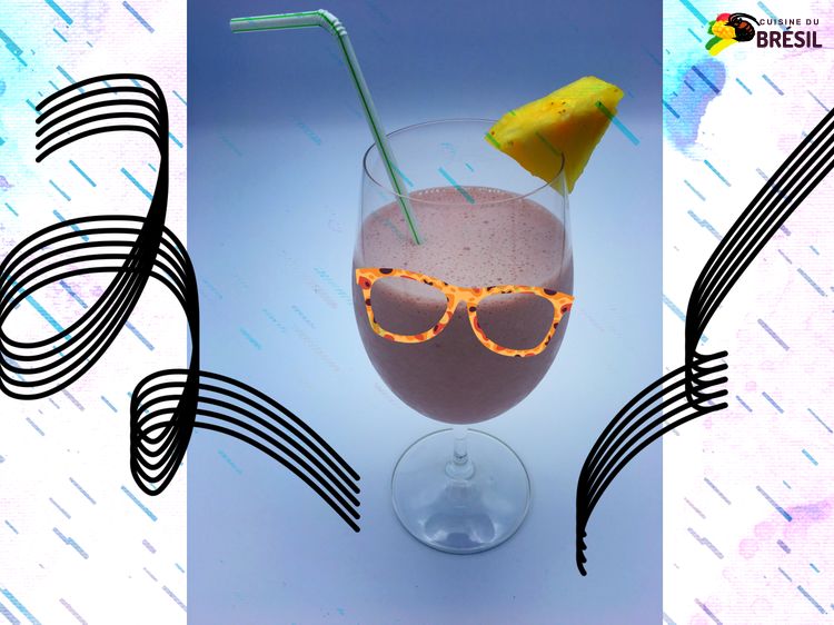 Un verre avec un cocktail brésilien à base de vin, ananas et lait concentré sucré