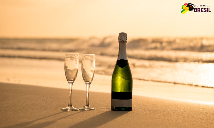 Une bouteille de champagne et 2 coupes sur le sable de la plage