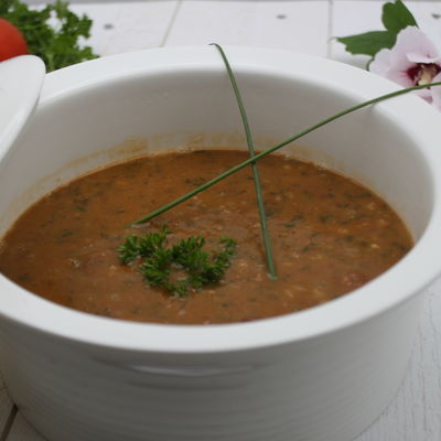 Bol de soupe aux haricots et chorizo avec décoration de ciboulette et persil