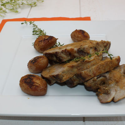 Rôti d'échine de porc au four avec du thym, pommes de terre et une belle sauce