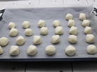Les petits pains brésiliens au fromage prêts pour aller au four, sur une plaque de cuisson.