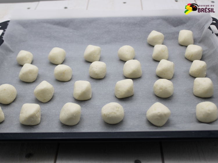 Les petits pains brésiliens au fromage prêts pour aller au four, sur une plaque de cuisson.