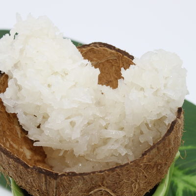 Cocada blanche brésilienne présentée dans la coquille d'une noix de coco.