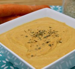 Un bol de soupe aux carottes avec un peu de persil séché saupoudré par dessus