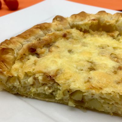 Un morceau de tarte aux échalotes et pommes de terre gratinée au tomme de montagne