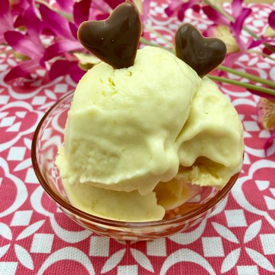 Une coupe de crème glacée à la mangue décorée avec 2 cœurs en chocolat