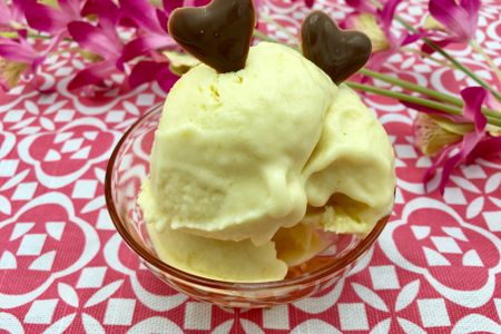 Une coupe de crème glacée à la mangue décorée avec 2 cœurs en chocolat