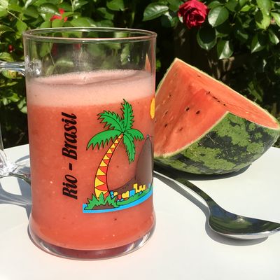 Un verre de jus de pastèque fraîche sur une table dans un jardin