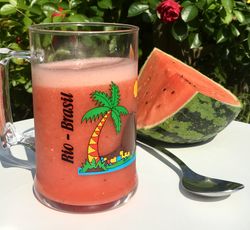 Un verre de jus de pastèque fraîche sur une table dans un jardin