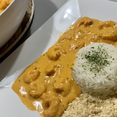 Stroganoff brésilien de crevettes servi avec riz blanc et farofa