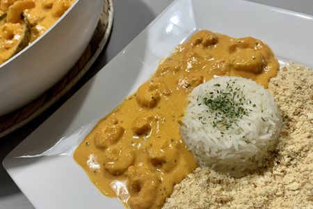 Stroganoff brésilien de crevettes servi avec riz blanc et farofa