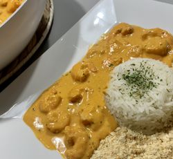 Stroganoff brésilien de crevettes servi avec riz blanc et farofa