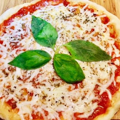 Pizza au fromage avec sauce tomate et feuilles de basilic cuite à la poêle