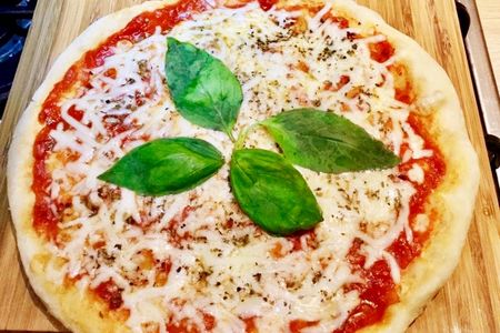 Pizza au fromage avec sauce tomate et feuilles de basilic cuite à la poêle